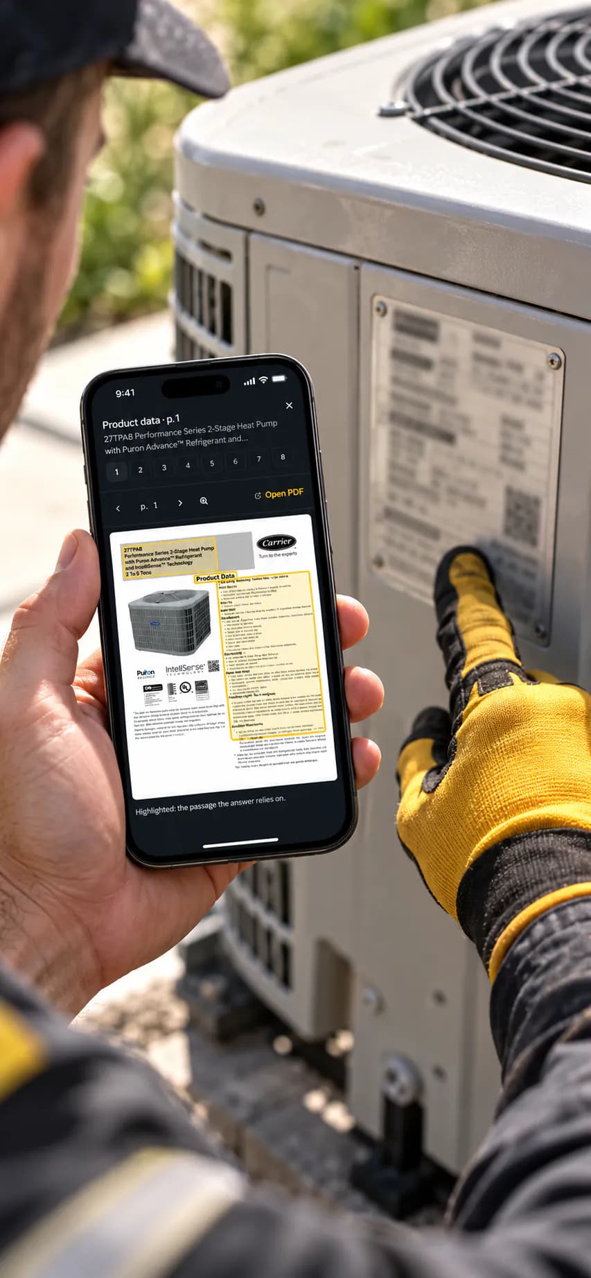 A technician in work gloves at the outdoor unit, checking the nameplate against Carrier product data, page 1, open in MyLeadTech on his phone.